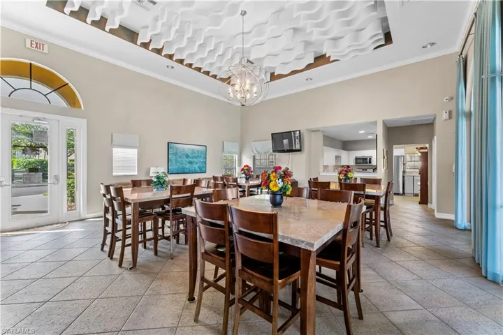 Dining space with crown molding, a towering ceiling, plenty of natural light, and a chandelier