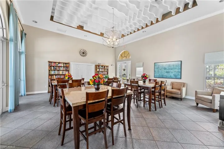 Dining space with ornamental molding, a towering ceiling, and a chandelier