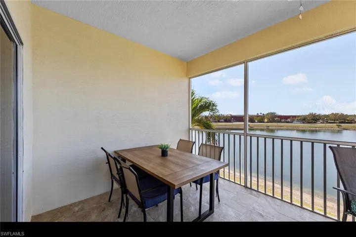 Screened Lanai featuring a water view, a textured wall, a textured ceiling, and stone finish flooring