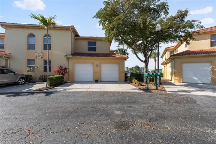Mediterranean / spanish-style house with stucco siding, a tiled roof, a garage, and driveway