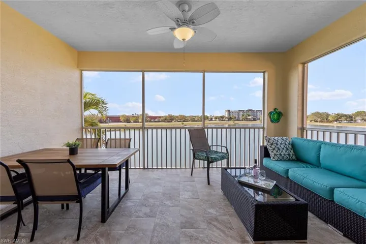 Lanai featuring a textured wall, a ceiling fan, an outdoor living space, stone finish flooring, and a textured ceiling