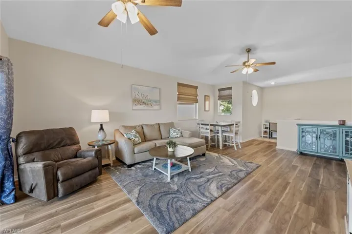 Living area with light wood-type flooring and a ceiling fan
