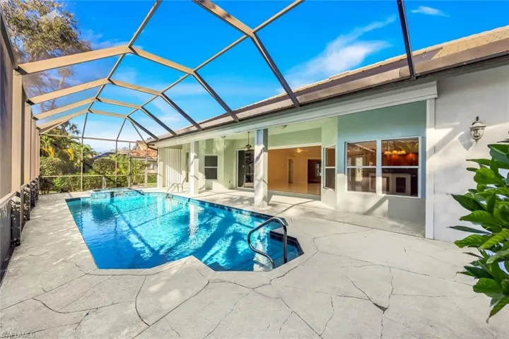 View of swimming pool featuring a sunroom, a patio, a lanai, and a pool with connected hot tub