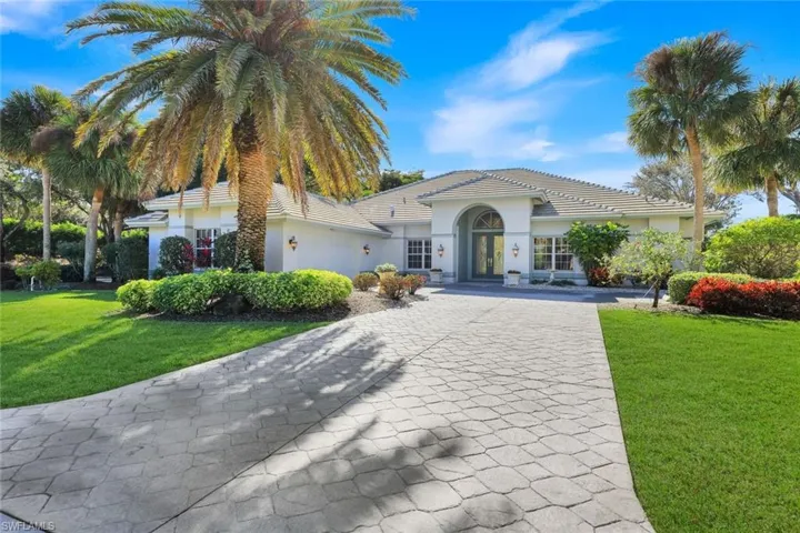 View of property with decorative driveway and a garage