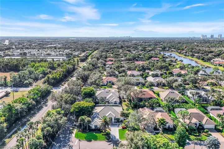 Aerial view of property and surrounding area featuring nearby suburban area and a large body of water