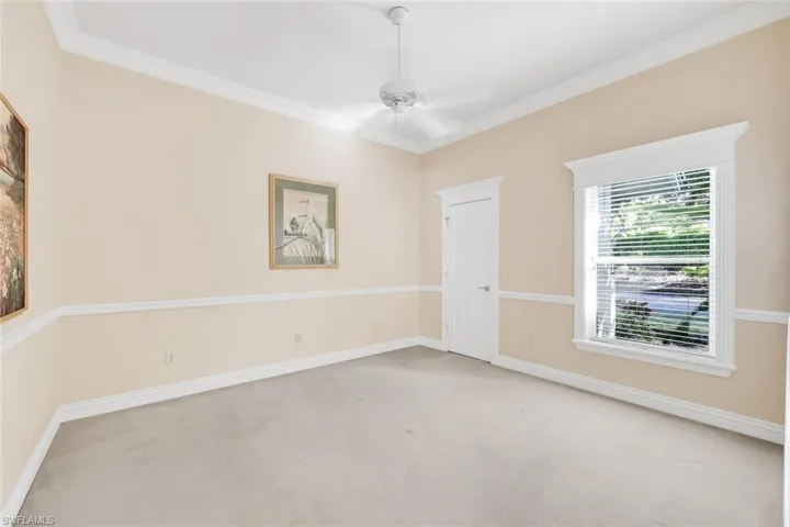 Empty room with crown molding, carpet flooring, and ceiling fan