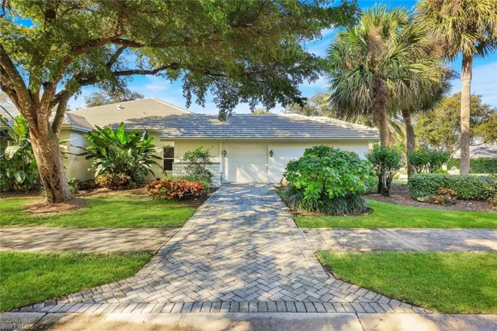 Ranch-style home with stucco siding, a garage, and a front yard