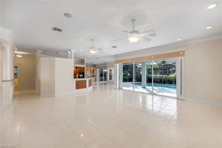 Unfurnished living room with ornamental molding, recessed lighting, light tiled floors