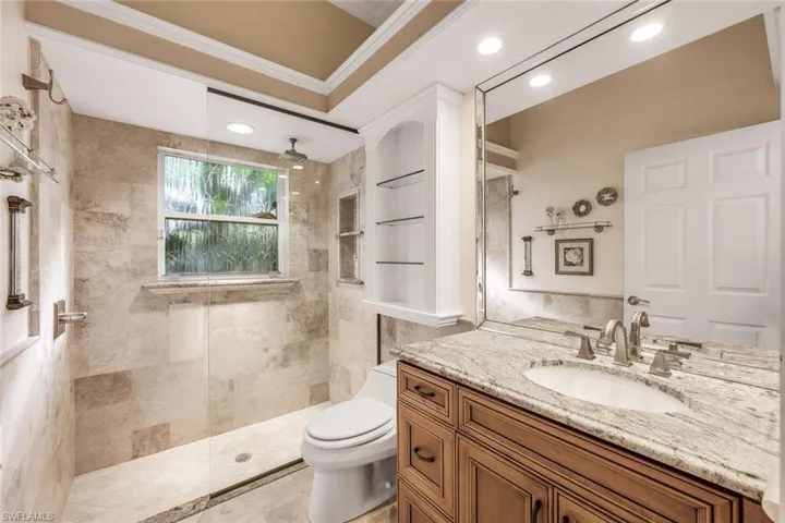 Bathroom with walk in shower, vanity, recessed lighting, and crown molding
