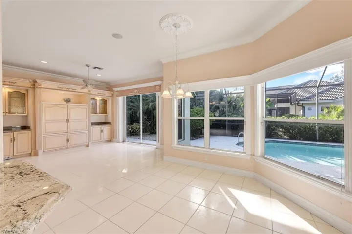 Unfurnished dining area with crown molding, a chandelier, light tile patterned floors, and ceiling fan