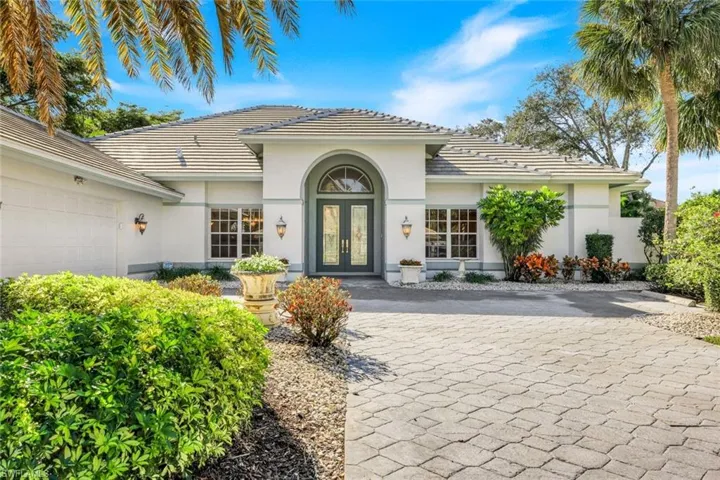 Property entrance featuring a tiled roof, french doors, and stucco siding