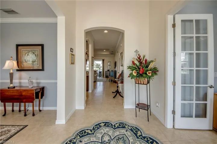 Foyer Featuring Arched Entryways, Crown Molding & French Doors