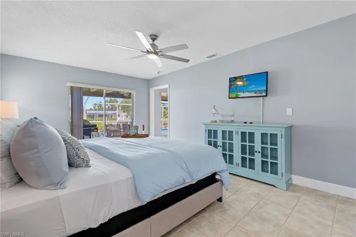 Bedroom featuring ceiling fan, a textured ceiling, and light tile patterned floors