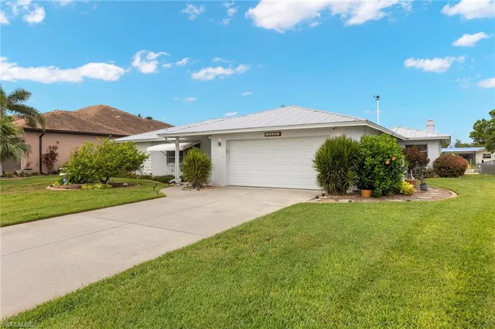Ranch-style home featuring a front yard and a garage