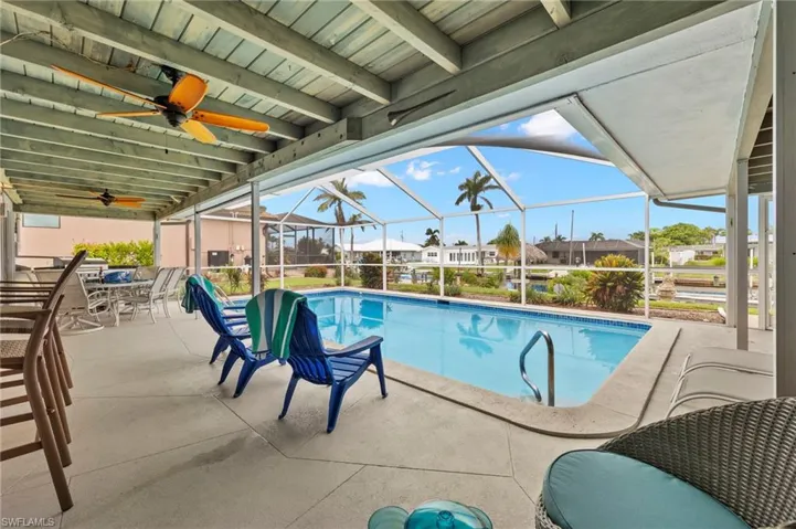 View of swimming pool enclosure, a patio, and ceiling fan