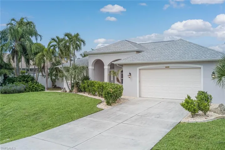 View of front of house with a shingled roof, stucco siding, a garage, concrete driveway, and a front yard