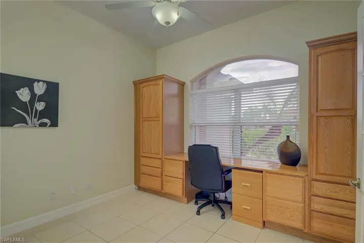 Office with light tile patterned floors and ceiling fan