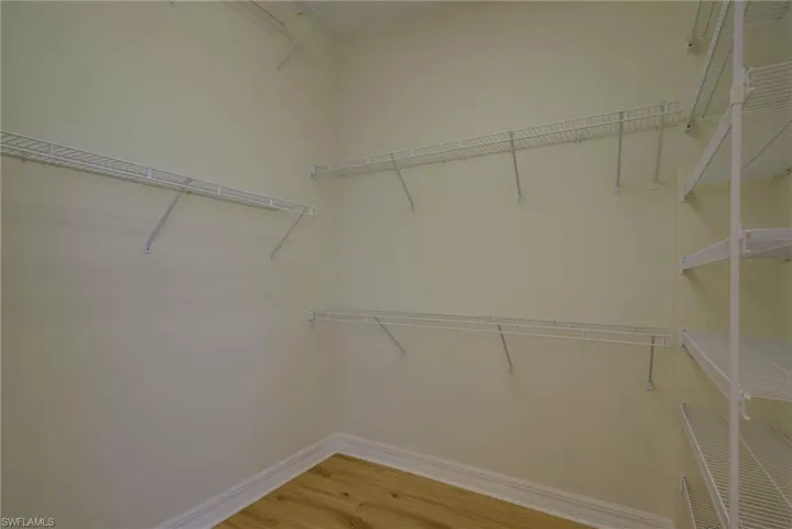 Walk in closet with light wood-style flooring
