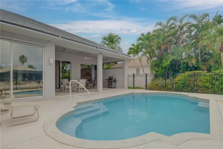 View of pool featuring a ceiling fan, a patio, and grilling area