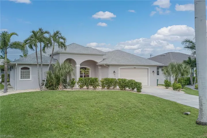 Ranch-style home with stucco siding, a front yard, an attached oversized 2 car garage, and driveway