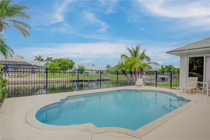 View of swimming pool with a water view and a patio