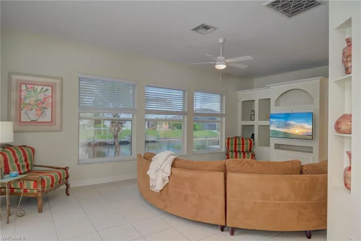 Living area with healthy amount of natural light, ceiling fan, and tile patterned floors