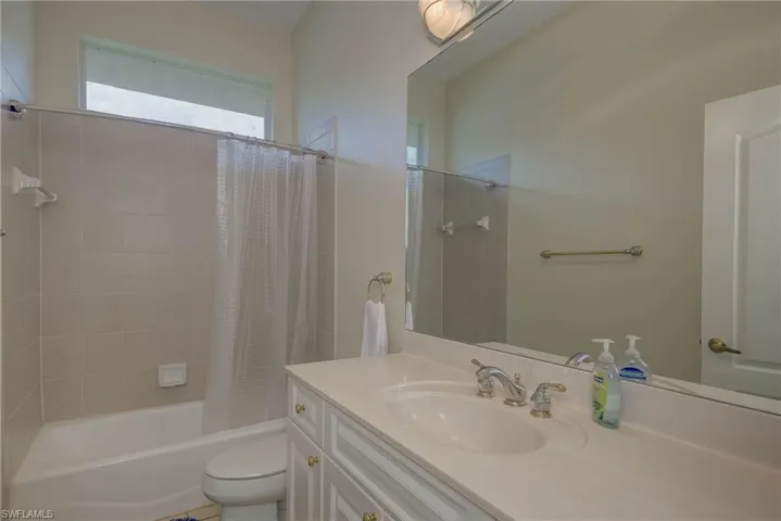 Full bathroom with shower / bath combination with curtain and vanity