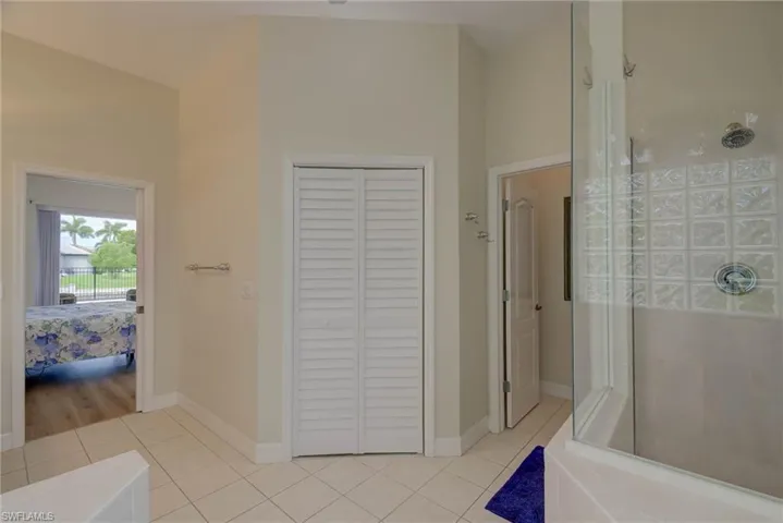 Full bath with a closet, a stall shower, light tile patterned floors, and ensuite bathroom