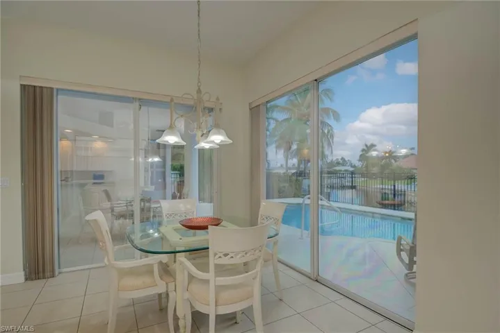 Dining room featuring a chandelier, light tile patterned floors, and a water view