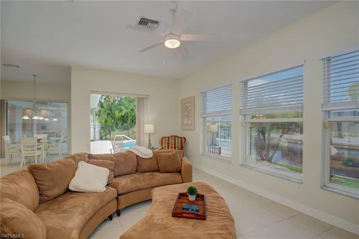 Living area featuring light tile patterned floors and ceiling fan