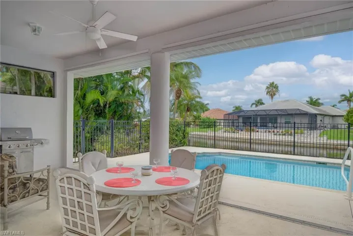 View of swimming pool with a patio area, ceiling fan, a residential view, and area for grilling
