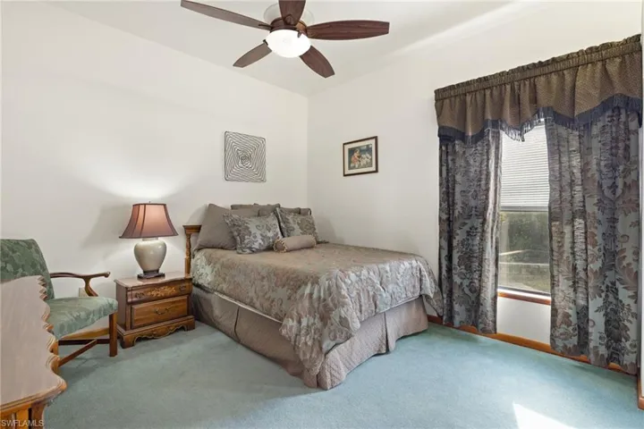 Carpeted bedroom featuring ceiling fan