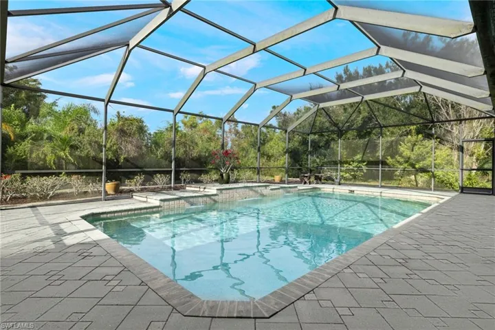 View of swimming pool featuring a patio and a lanai