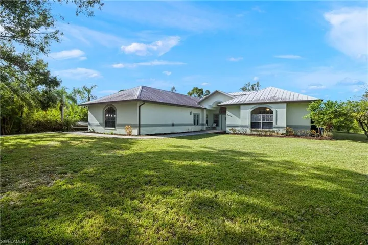 Rear view of house featuring a lawn