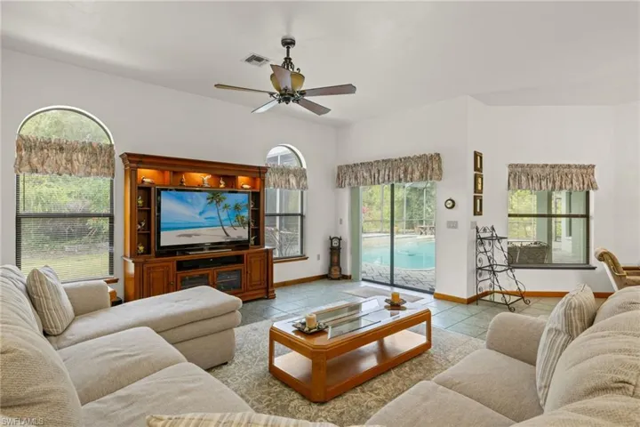 Living room with ceiling fan and light tile patterned floors