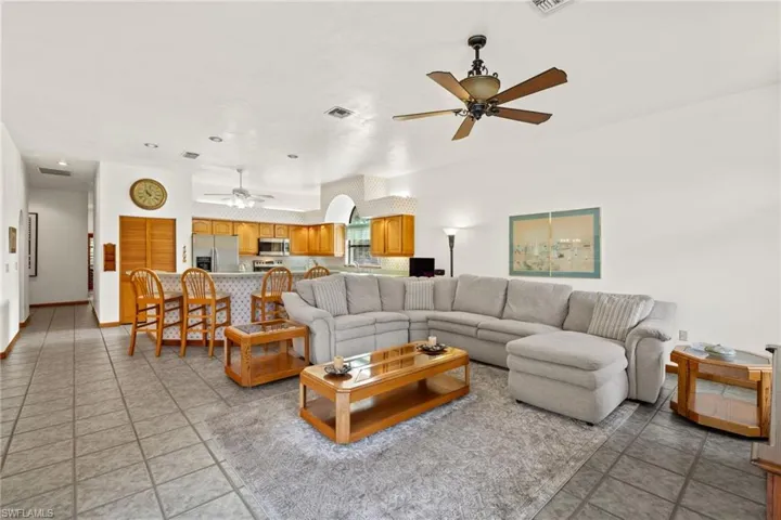 Living room featuring light tile patterned floors and ceiling fan
