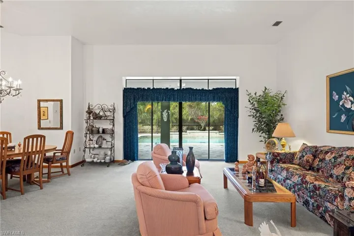 Carpeted living room with a chandelier