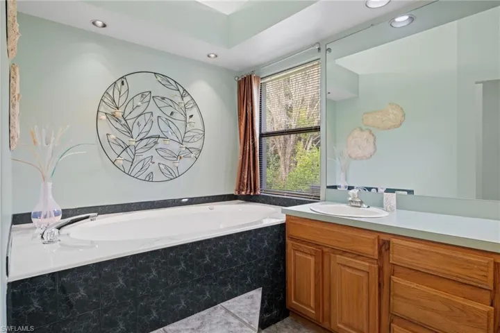 Bathroom featuring vanity and tiled bath