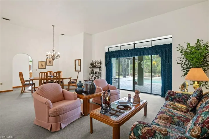 Carpeted living room with a chandelier