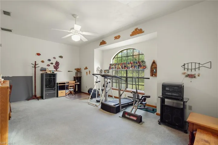 Exercise area with ceiling fan and carpet