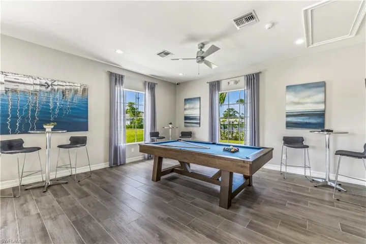 Recreation room with ceiling fan, pool table, and dark wood-type flooring
