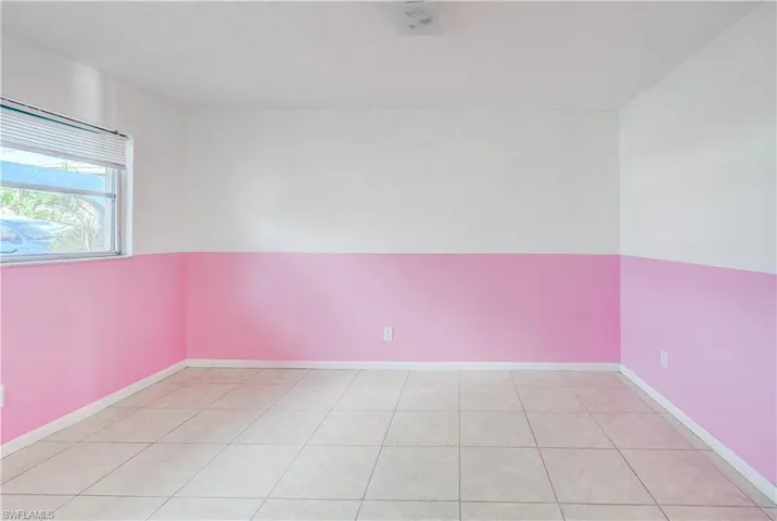 Spare room featuring light tile patterned flooring and baseboards