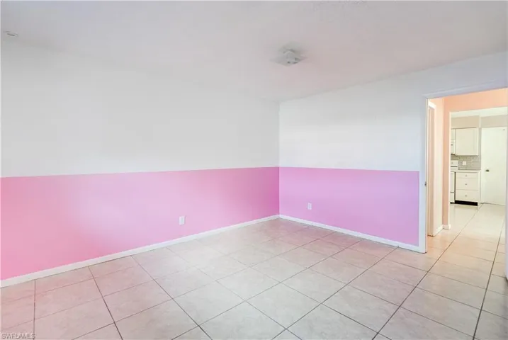 Spare room featuring light tile patterned floors and baseboards