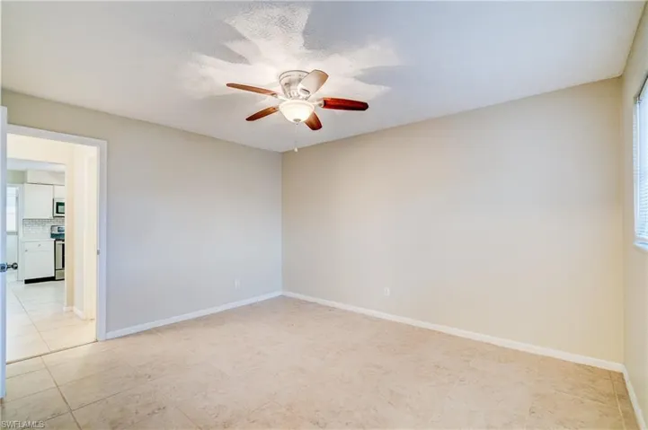 Empty room featuring ceiling fan and light tile patterned floors