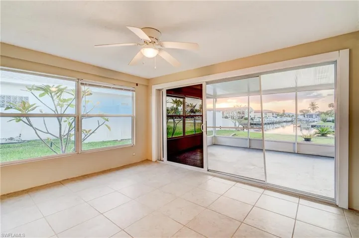 Unfurnished room with light tile patterned floors and ceiling fan