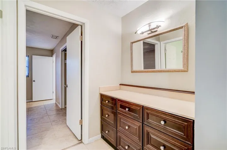 Bathroom featuring a textured ceiling, tile patterned flooring, and vanity