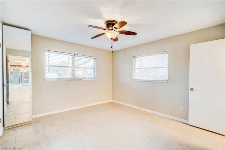Empty room featuring ceiling fan and light tile patterned floors