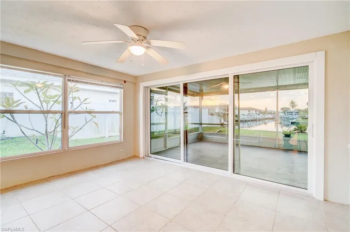 Unfurnished sunroom with a water view and ceiling fan