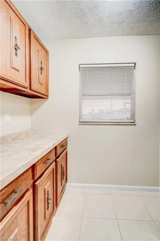 Washroom featuring light tile patterned floors and a textured ceiling