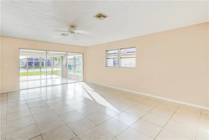Spare room with light tile patterned floors, a textured ceiling, and a ceiling fan